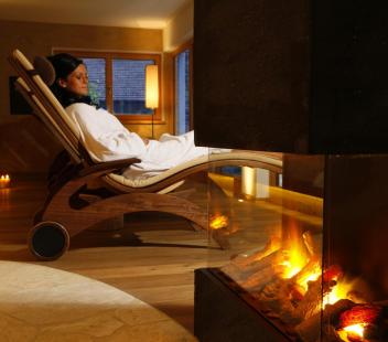 A woman relaxes at the fireplace in the relaxation room