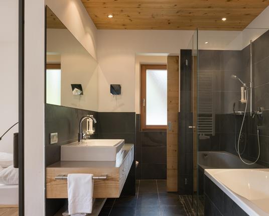 Das Badezimmer der Panorama Suite mit Dusche und Badewanne