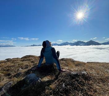 A woman enjoys the sun during a hike