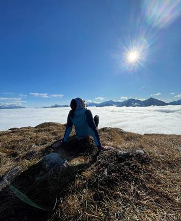 A woman enjoys the sun during a hike